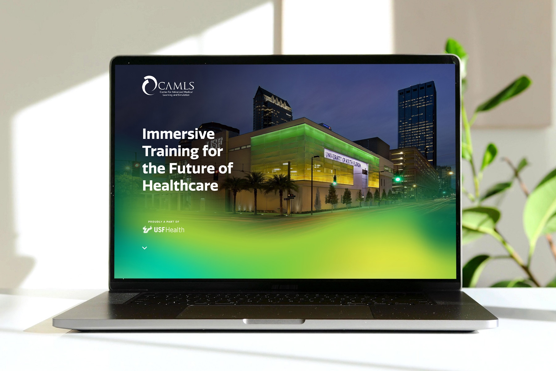 CAMLS website on a laptop screen with an image of their illuminating building and headline: Immersive Training for the Future of Healthcare